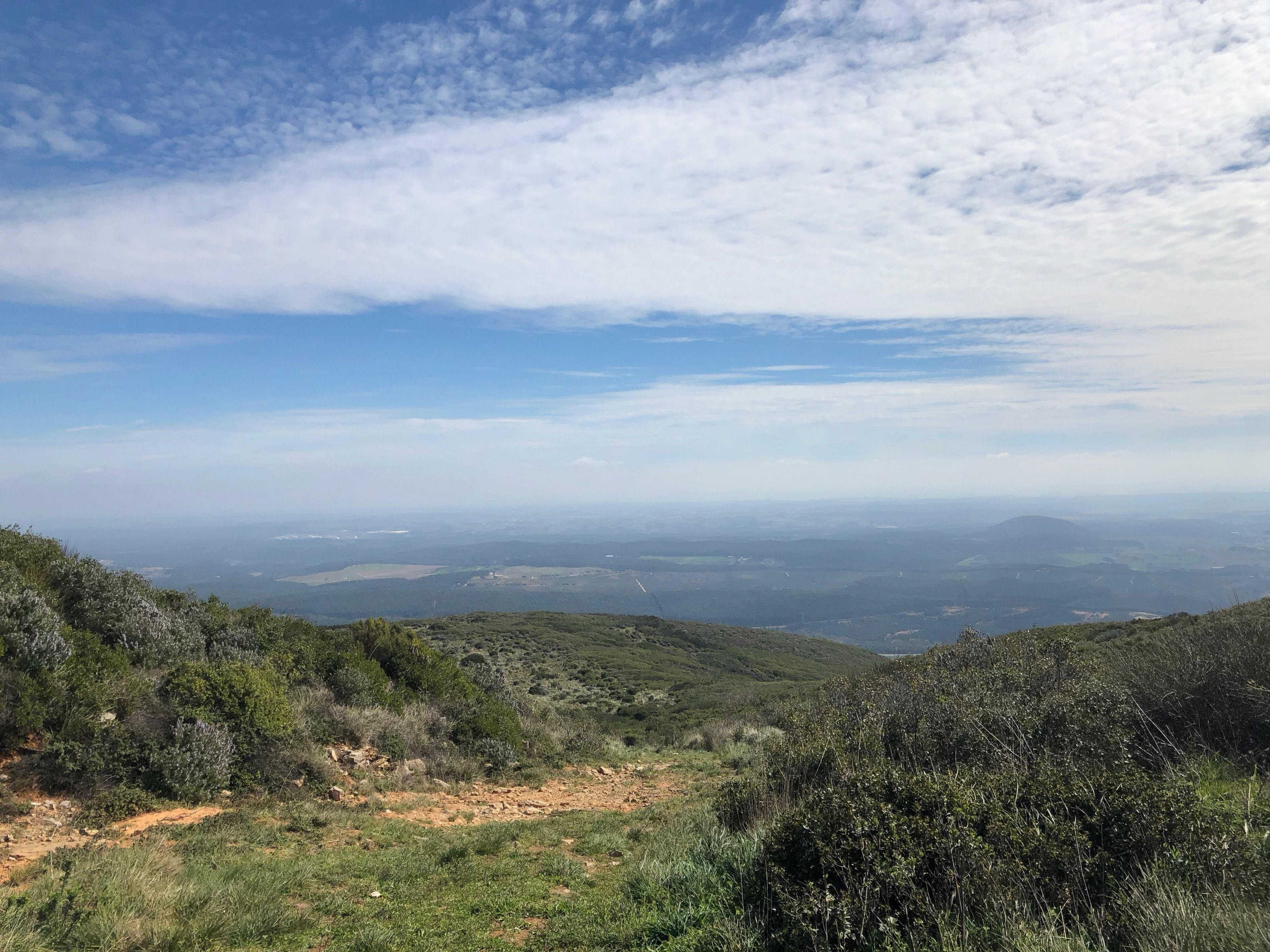 Una vista panorámica de un paisaje montañoso con cielo despejado y colinas lejanas.