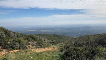 Una vista panorámica de un paisaje montañoso con cielo despejado y colinas lejanas.