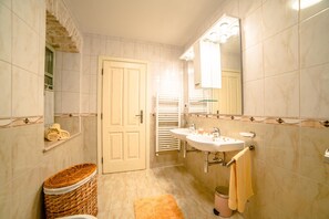 A bathroom with a white door, two sinks, a mirror, and a towel rack. - Villa Bubani / Private Pool (Kanfanar)