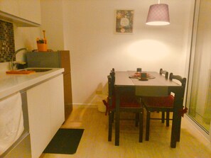 Eine kleine Küche mit Essbereich, einem Tisch und Stühlen.
