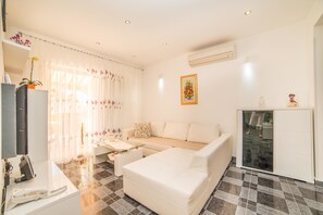 Apartment, Mehrere Betten | Wohnzimmer | Fernseher