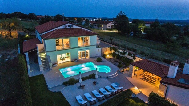 A two-story house with a swimming pool, outdoor seating, and a well-lit patio area. - Istrian Villa Lavanda (Kanfanar)