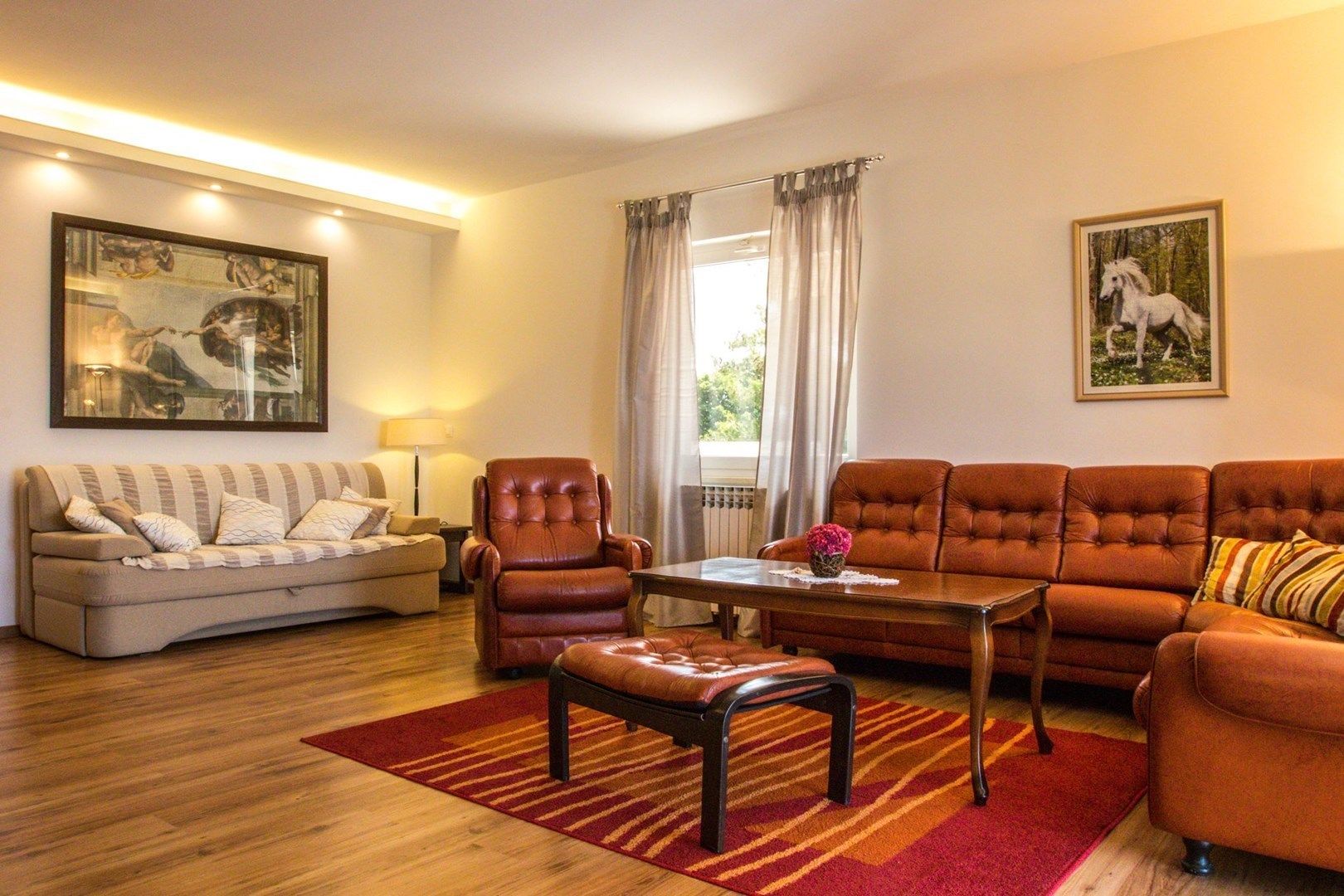 A living room with a sofa, armchair, ottoman, and a coffee table.