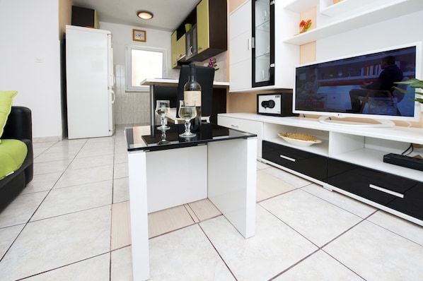 Relax in style with a sleek desk, flat-screen TV, and cozy seating area.