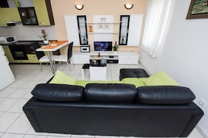 Relax in this stylish living space with a comfortable sofa, dining area, and entertainment unit.