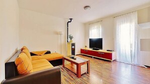 Un salon moderne comprenant un canapé, une table basse, un téléviseur et un meuble.