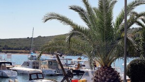 A marina with boats, a large palm tree, and an anchor sculpture.