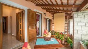 A cozy interior with a wooden table, a basket of bread, and a wooden ladder leading to a balcony with plants. - Apartment Andrea / Galery one Bedroom (Vodnjan)