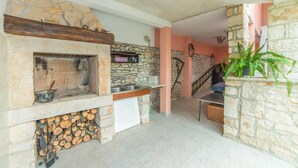 A stone fireplace with a wooden mantel, a sink, and a staircase leading to an upper level. - Apartment Andrea / Galery one Bedroom (Vodnjan)