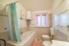 A bathroom with a bathtub, toilet, and sink. - Apartment Andrea / Galery one Bedroom (Vodnjan)