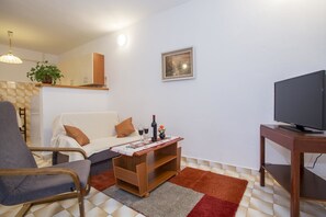 Apartment, Mehrere Betten | Wohnzimmer | Fernseher