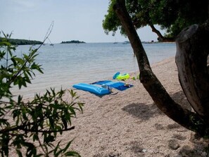A beach with a tree and a sandy shore. - Apartment Tomy / Studio Terrace A1 (Rovinj)