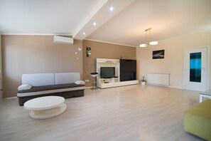 A modern living room with a sofa, a TV, and a round coffee table.