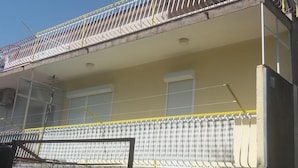 A building with a balcony, a window, and a door.