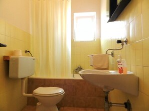 Un baño con inodoro, lavamanos y ducha.