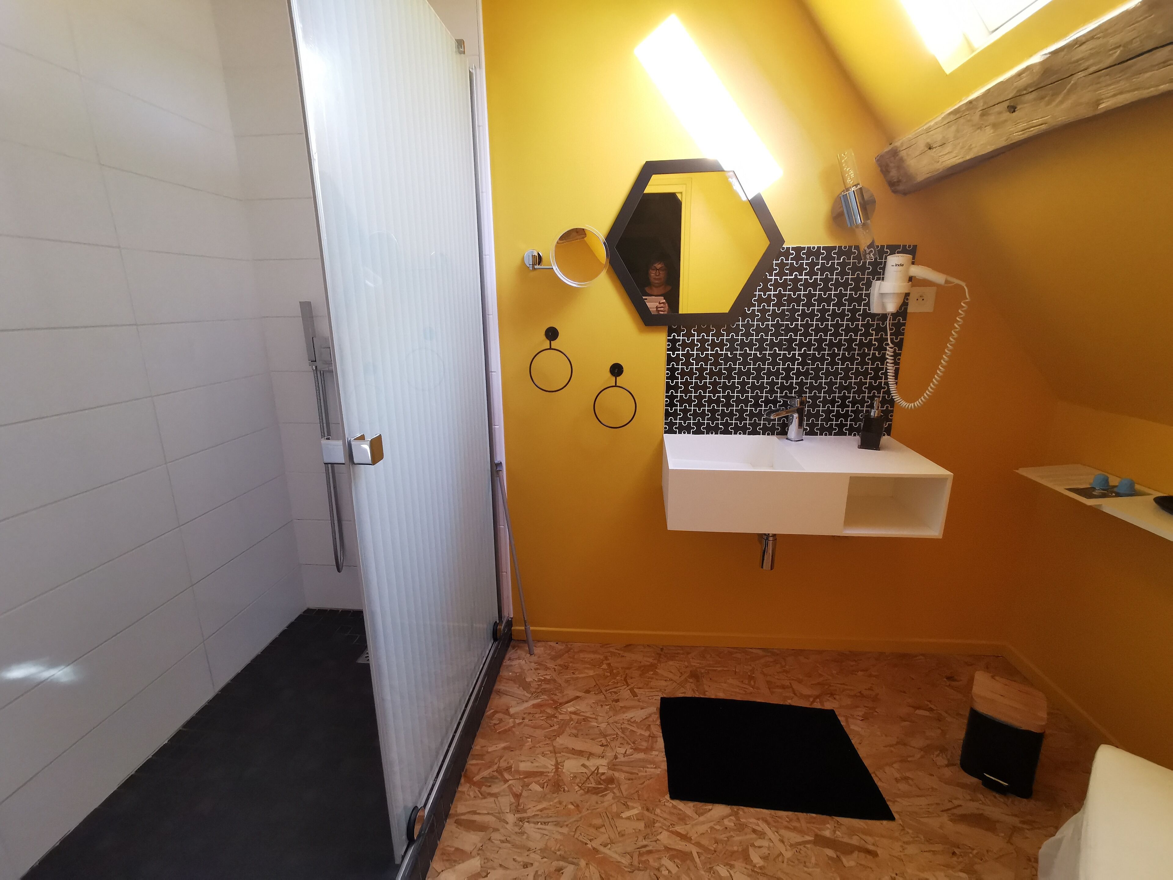 A bathroom with a shower, a sink, and a mirror.