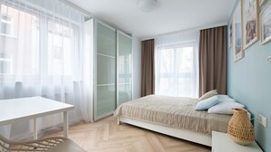 Une chambre à coucher moderne avec un lit, un bureau et une chaise.