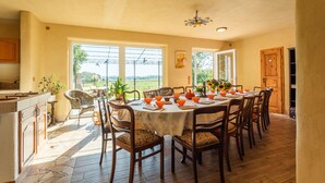 A dining area with a round table, chairs, and a view of the outdoors. - Ostsee Ferienhaus Welzin - Schulgartenhaus (Damshagen)