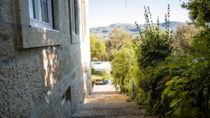 A stone staircase leading to a pool area surrounded by lush greenery and a mountain view.