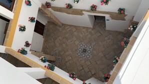 Ein großzügiger Innenbereich mit gefliestem Boden, verschiedenen Blumenarrangements und einer Treppe, die zu einer oberen Ebene führt.