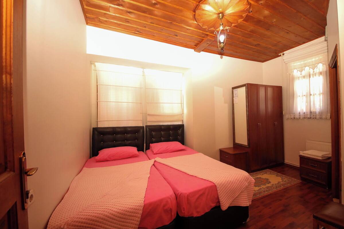 Une chambre à coucher avec un lit double, un plafond en bois et une armoire.