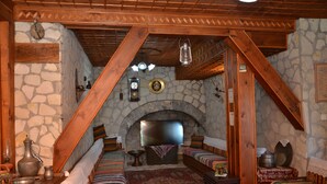 Una habitación acogedora con chimenea de piedra, vigas de madera y ropa de cama a rayas.