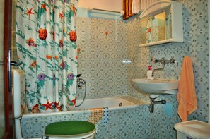 A bathroom with a bathtub, a sink, and a toilet. - Apartments Pavica Savarin (Starigrad)