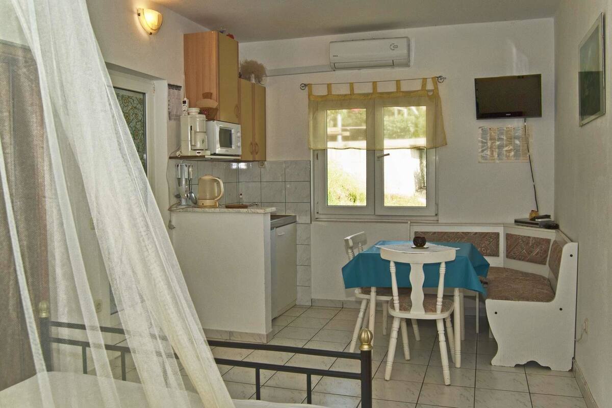 A compact kitchen with a microwave, coffee maker, and a small dining area with a table and chairs.