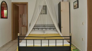A bed with a canopy, a wardrobe, and a mirror on the wall.