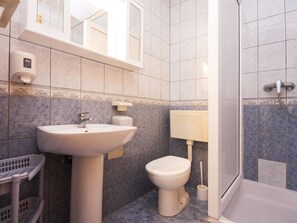 A bathroom with a sink, toilet, and shower. - Apartments Skarpa (Rogoznica)