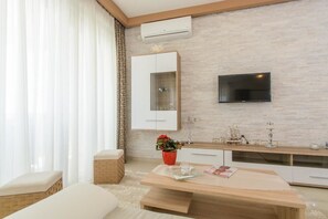 Apartment, Mehrere Betten | Wohnzimmer | Fernseher