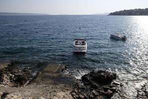 A rocky shoreline with a small boat anchored near the edge.