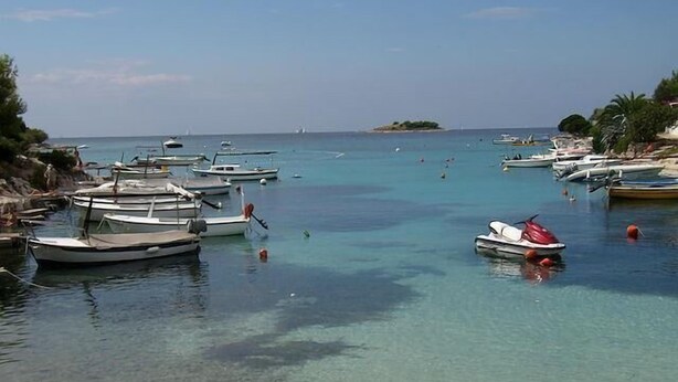 A marina with several boats docked, clear turquoise water, and a small island in the distance. - Apartments Ivan Rogoznica (Rogoznica)