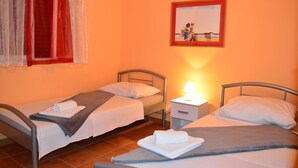 A room with two single beds, a nightstand with a lamp, and a painting on the wall. - Apartments Branko / Joanna / Two Bedrooms (Tribunj)