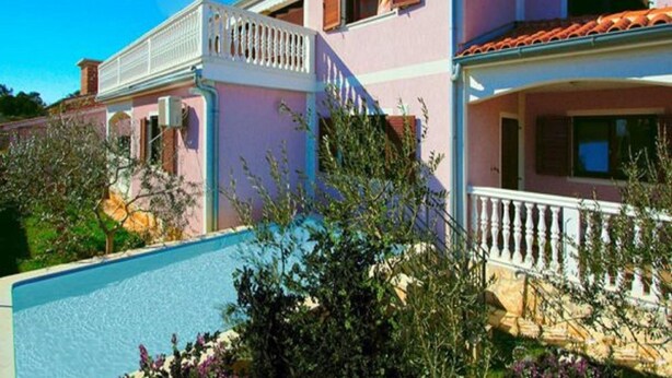 A two-story building with a balcony, a swimming pool, and a garden area. - Istrian Villa Iva (Medulin)