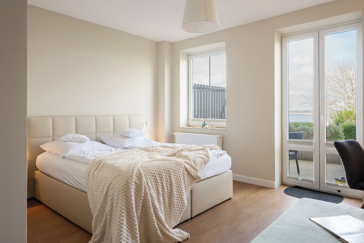 A bedroom with a bed, a window, and a view of the outdoors.