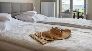 A hotel room with two beds, a view of the sea, and a window with a view of the outdoors. - Alte Fischereischule (Eckernfoerde)