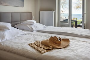 Ein Hotelzimmer mit zwei Betten und Meerblick, ein Fenster mit Blick ins Freie.