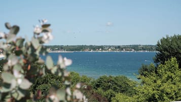 A coastal view with a clear sky, a body of water, and a distant shoreline with buildings.