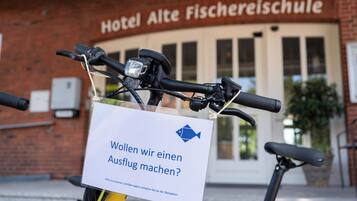 Ein Fahrrad mit einem Schild, auf dem darum gebeten wird, vor dem Hotel Alte Fischereisule einen Stellplatz zu finden.
