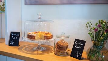 A dessert display with a cake and cookies, each with a price tag.