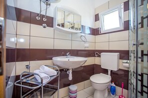 A bathroom with a sink, toilet, and a towel rack.