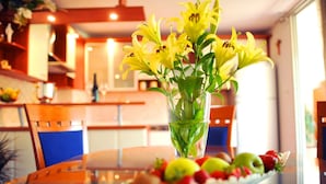 Ett matbord med en blomsterdekoration i mitten och ett fat med frukt.