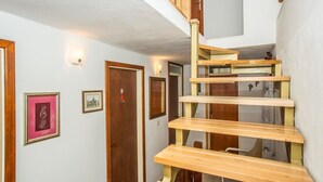 Un escalier avec des marches en bois et une rampe en verre, menant à un deuxième étage.