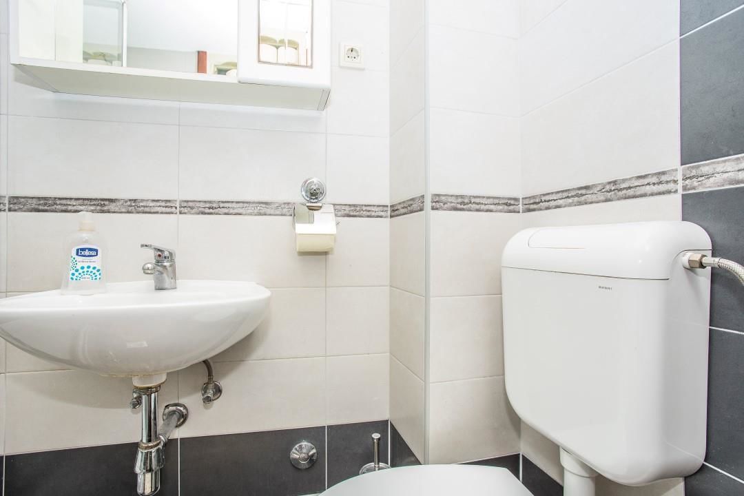 Ein Badezimmer mit Waschbecken, Toilette und Spiegel über dem Waschbecken.