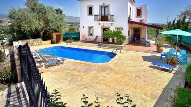 A two-story house with a swimming pool, outdoor seating, and a view of the surrounding landscape. - Villa Christodoula (Polis)
