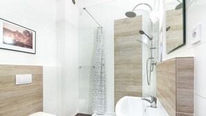 A modern bathroom with a toilet, shower, and sink. - Deer Apart (Cieszyn)