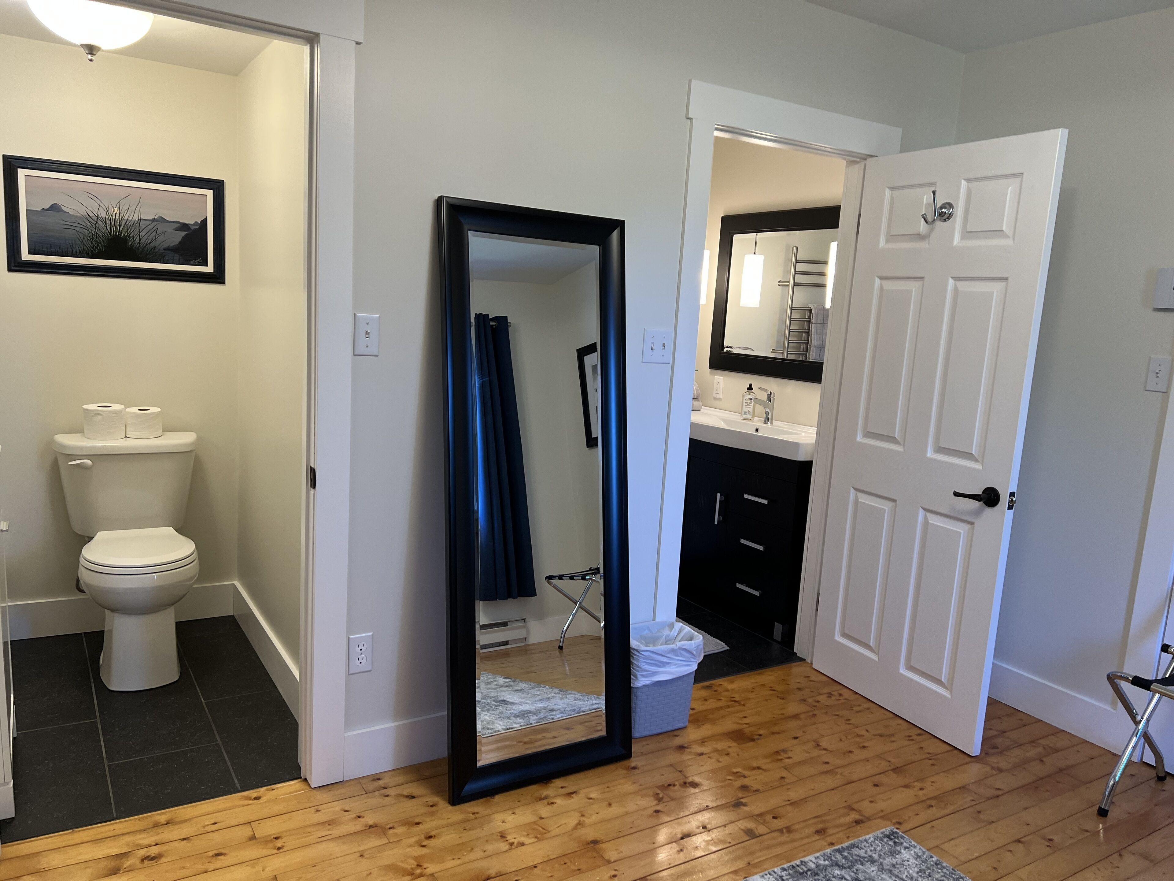 A bathroom with a toilet, a sink, and a mirror.