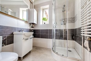 Appartement | Badkamer | Een douche, een haardroger, handdoeken