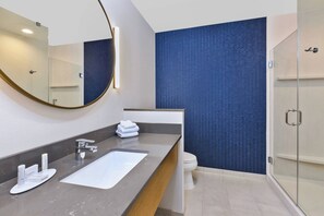 Une salle de bain moderne avec un grand miroir, un lavabo et des toilettes.